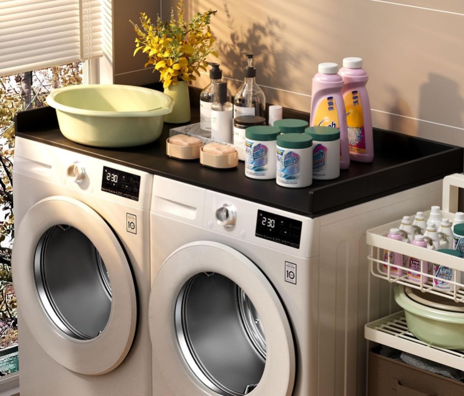 black washer and dryer counter top with laundry products on top