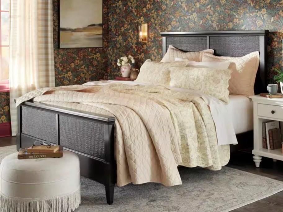 black bedframe with tan comforter on top 