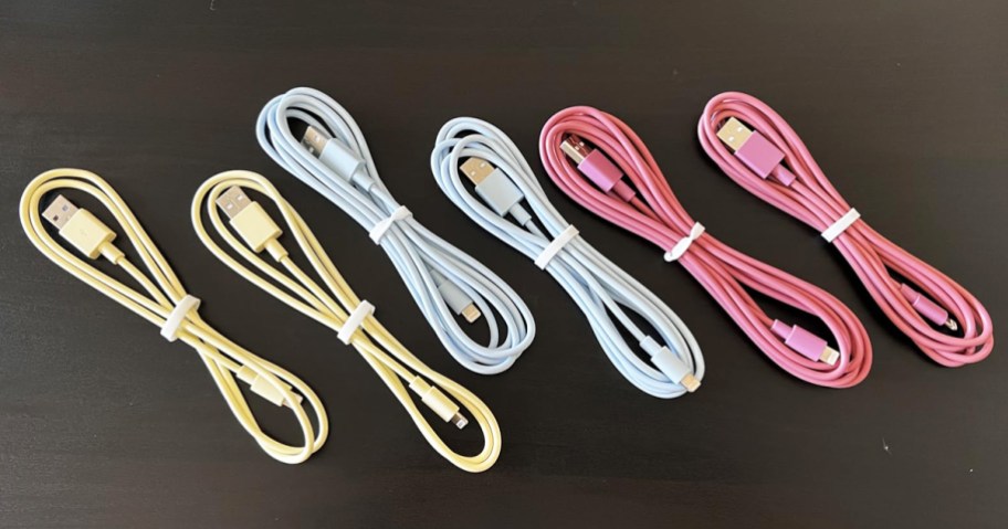 6 yellow, blue, and pink charging cables on a table