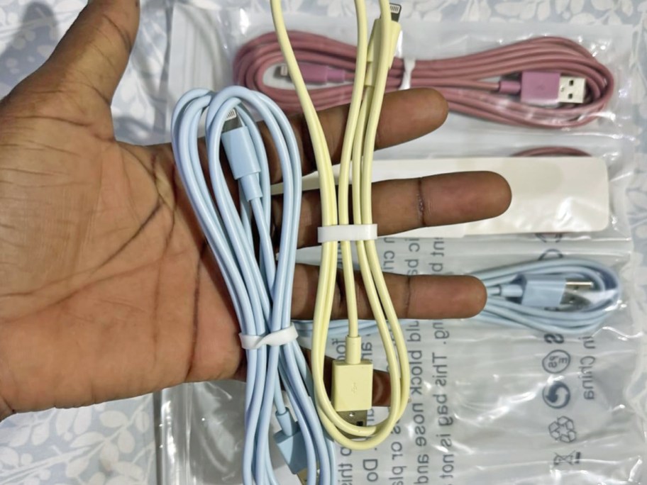 hand holding blue and yellow charging cables