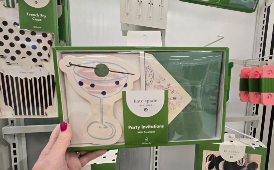 a womans hand holding a box of party invites