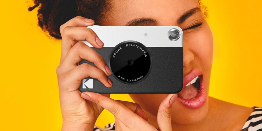 woman holding white and black kodak camera 
