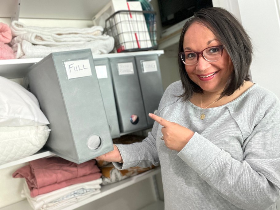 woman pointing to a bed linen organizer in her closet