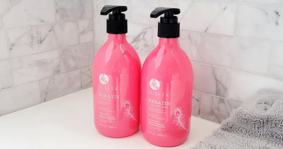 shampoo and conditioner in pink bottles by bathtub