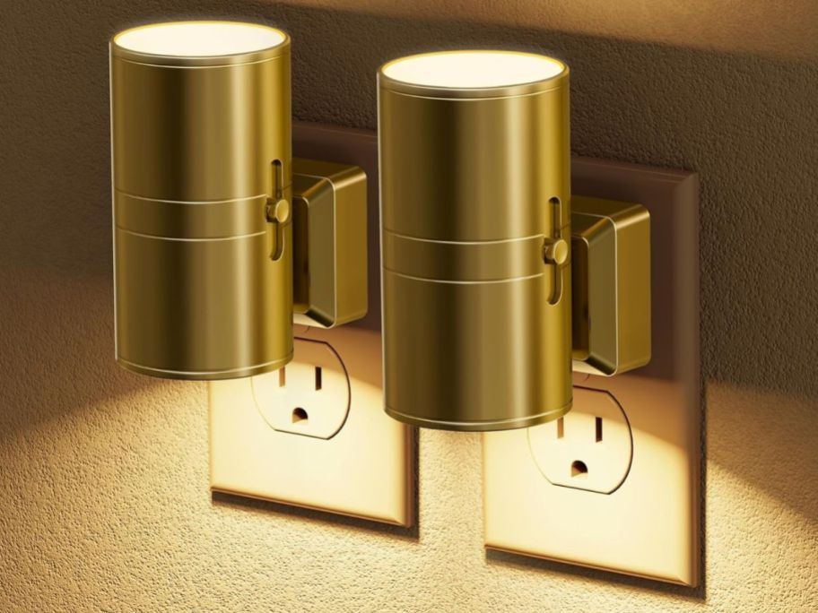 two gold night lights in outlet on wall