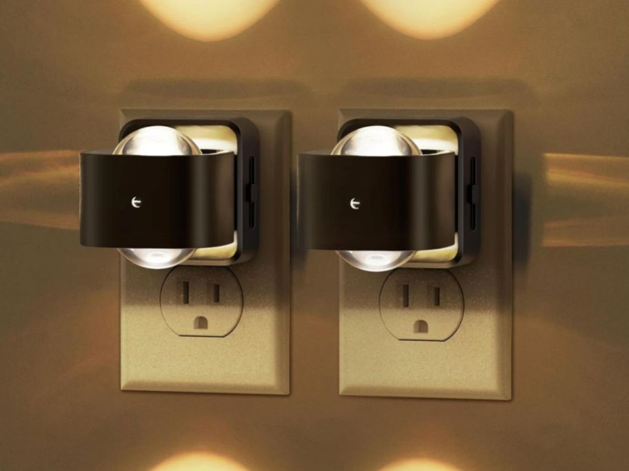 two black night lights in outlet on wall