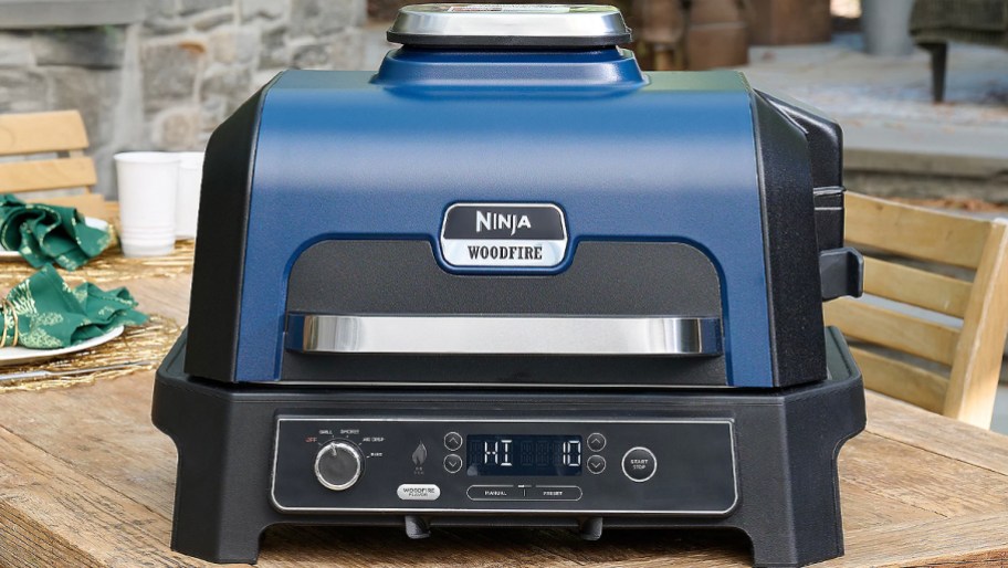 blue and black ninja woodfire grill on table 