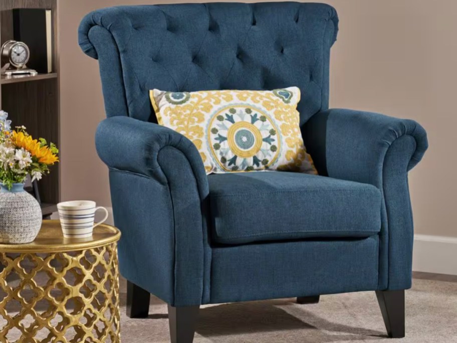blue tufted chair with yellow pillow 