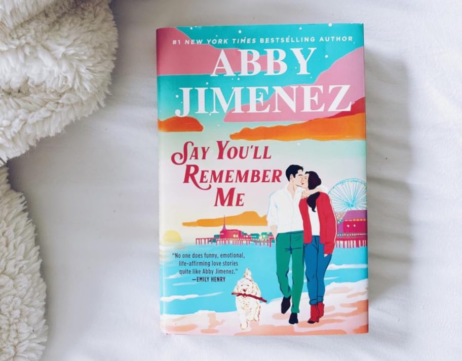 Say you'll remember me book on white sheet next to fur blanket
