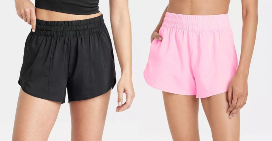 two women wearing black and pink shorts 