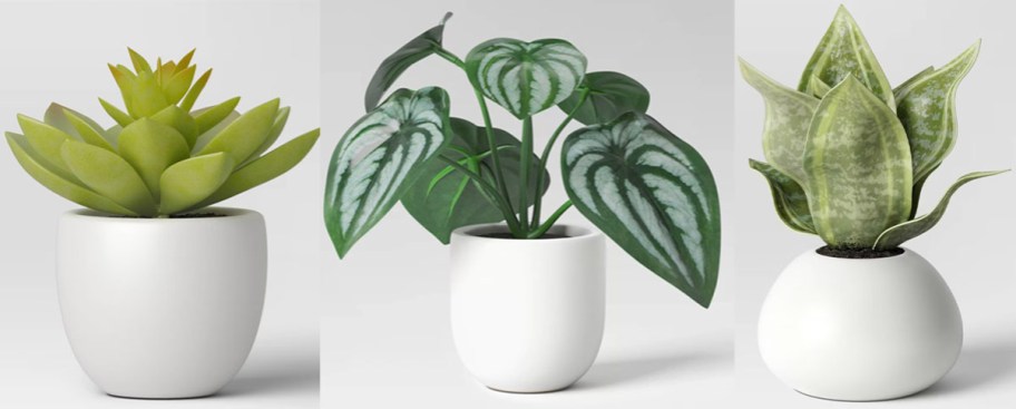 three artificial plants in white pots 