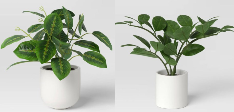 two artificial plants in white pots 