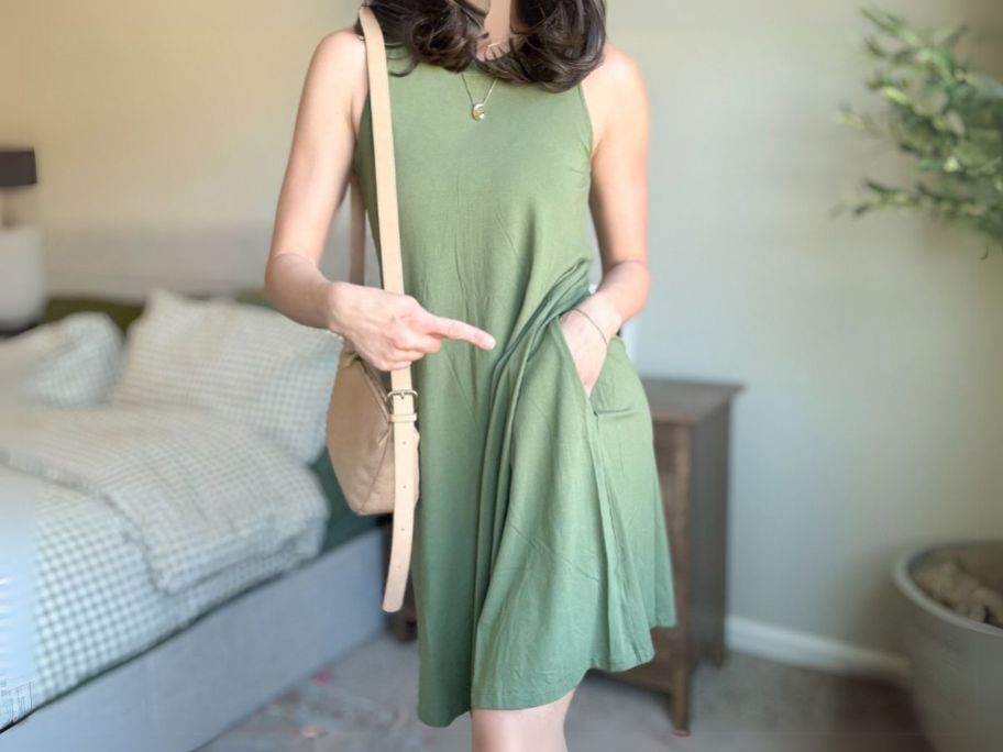 woman wearing green Time and Tru Women's Sleeveless Swing Dress with hand in her pocket