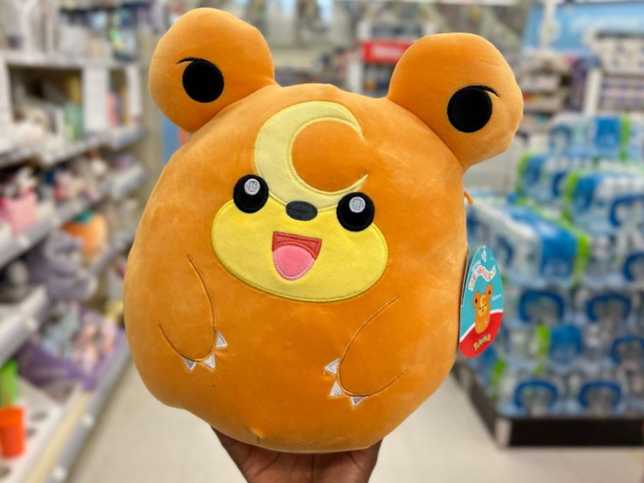hand holding a Squishmallows Pokemon Teddiursa plush