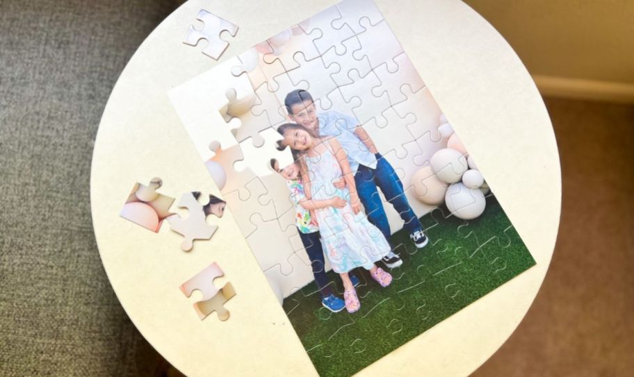 photo puzzle on circle table with a few pieces laying around it 