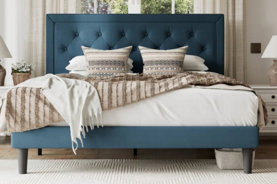 teal upholstered bed with pillows