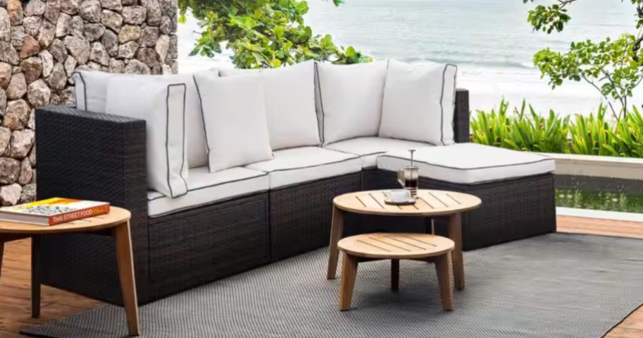 a wicker outdoor sectional with beige cushions on a back patio