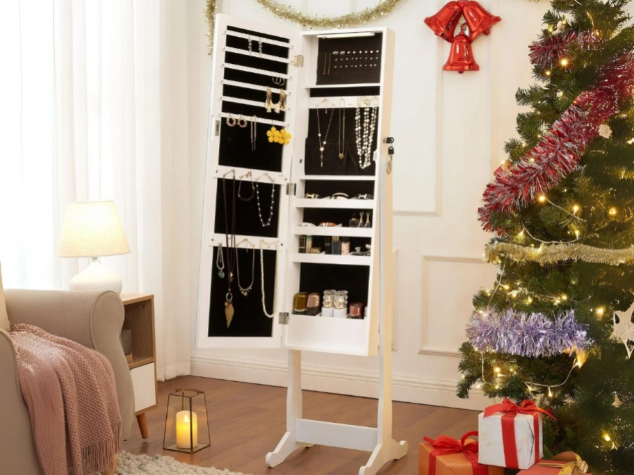 a jewelry armoire with the door open showing the inside sections with jewelry
