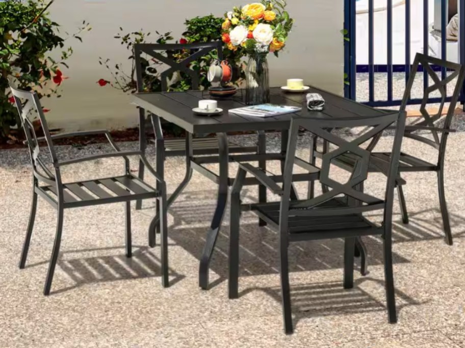 a metal patio dining set with a table and chairs on a back patio