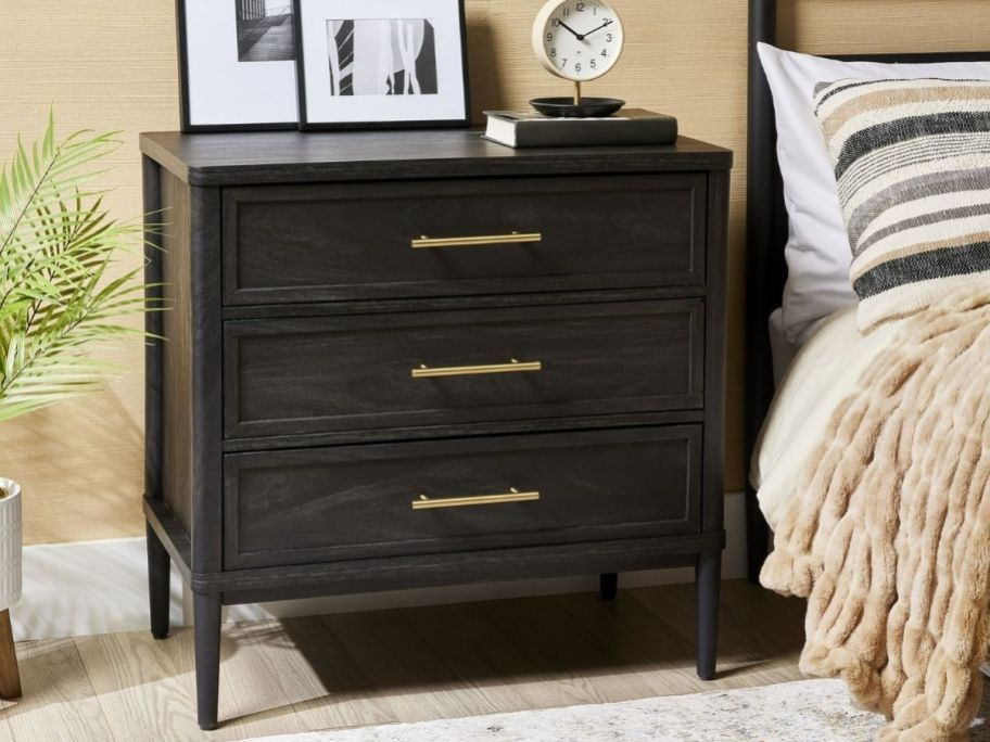 a charcoal colored wood 3 drawer nightstand