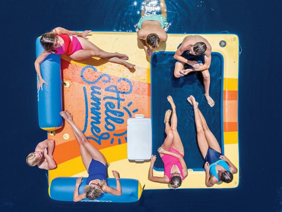 people sitting on a floating dock in the water