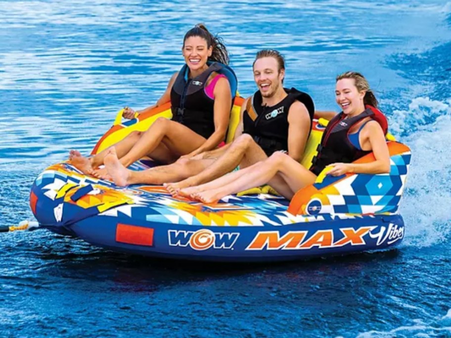 3 people in a large towable float raft in the water