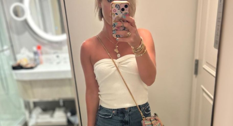 Woman wearing a beige tube top from amazon in front of a mirror 