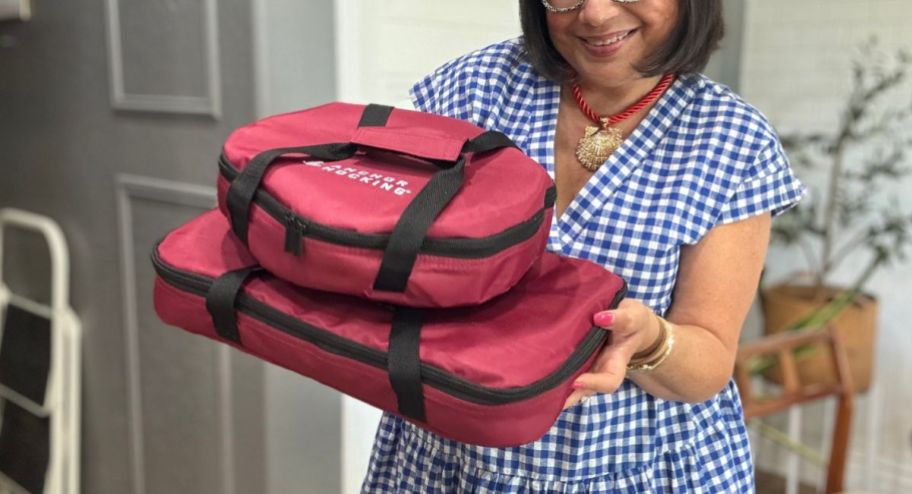 Woman showing the achor bakeware totes stacked on eachother wearing a gingham print dress