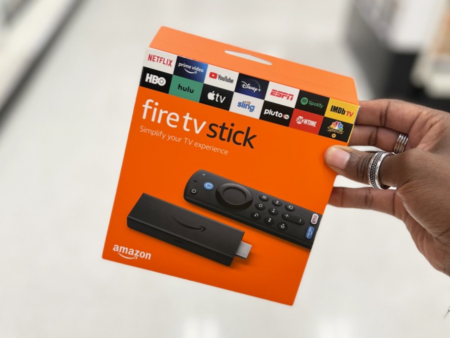 hand holding orange box to Amazon Fire TV Stick
