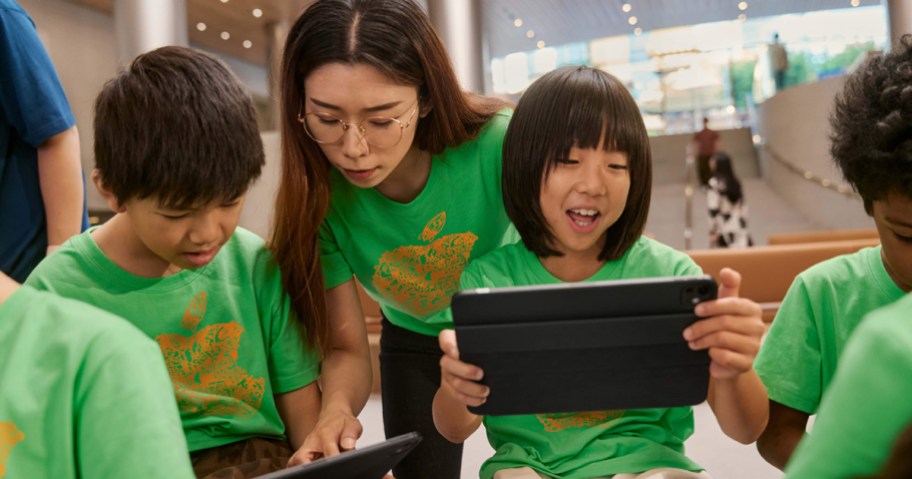 kids in matching green shirts working on ipads