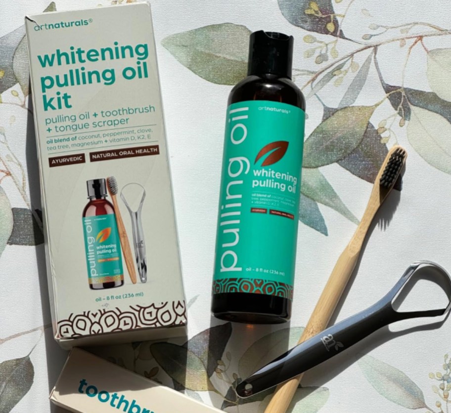 bottle of pulling oil, bamboo toothbrush, and tongue scraper 