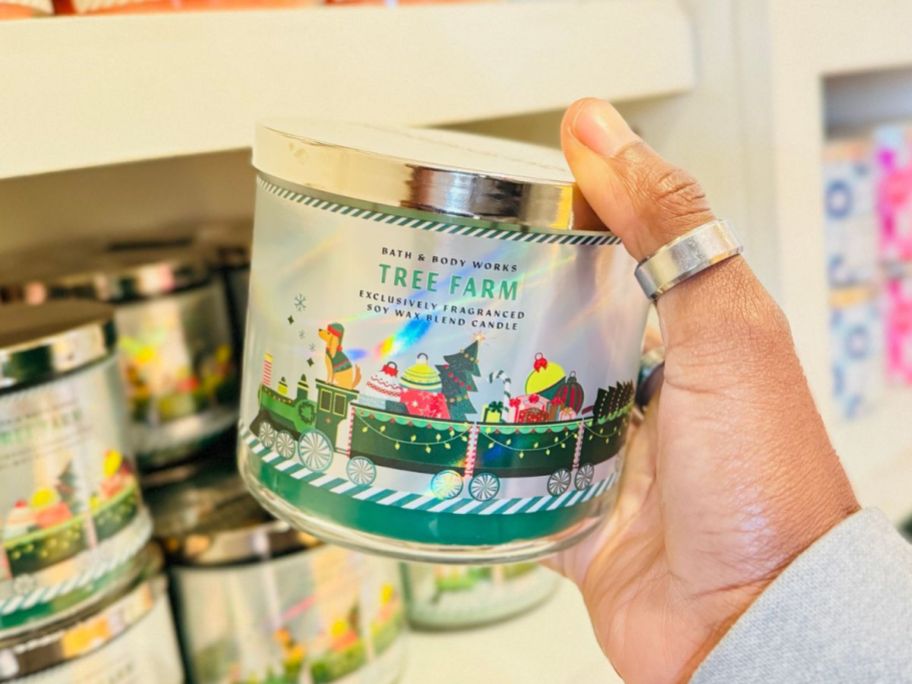 Hand holding a Tree Farm 3-Wick Candle