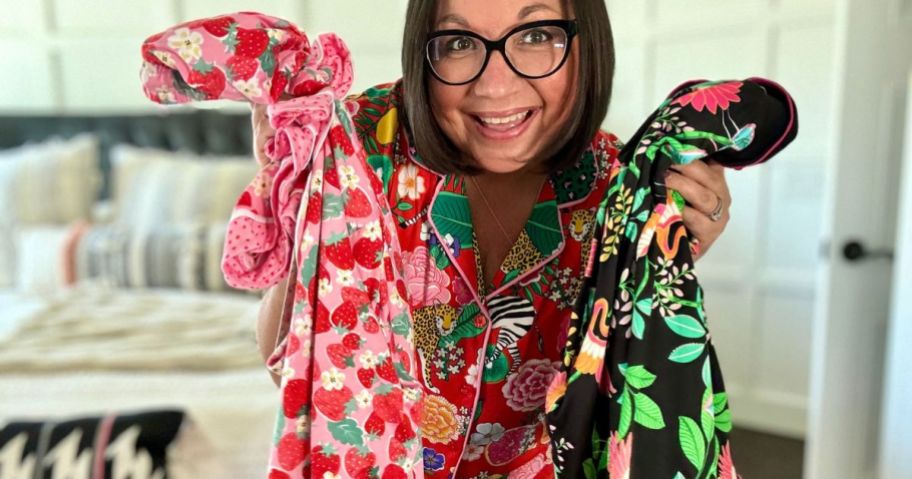 Women wearing beauty sleep social pajamas while holding two more pajama sets