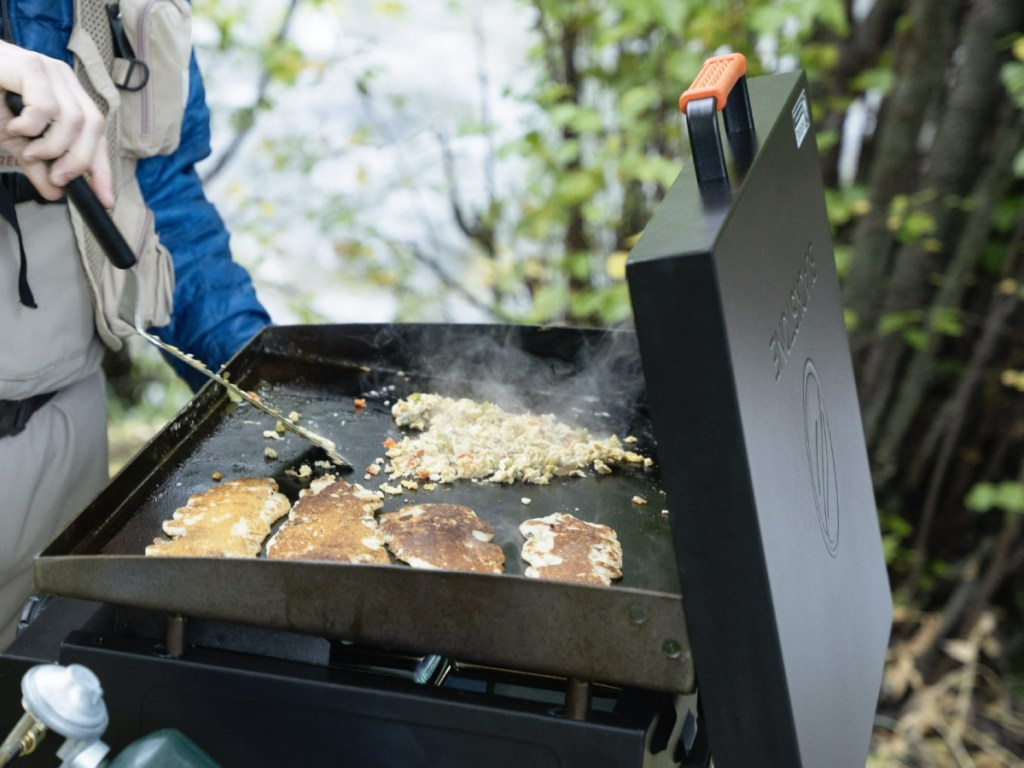 Man, cooking food outside on Blackstone griddle