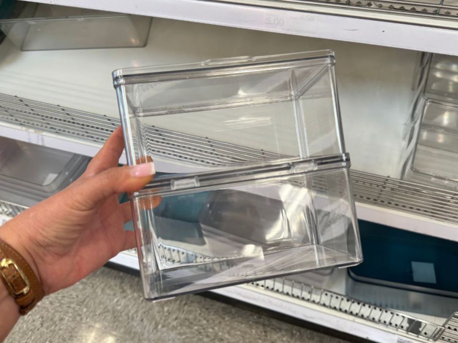 A person holding plastic bins 