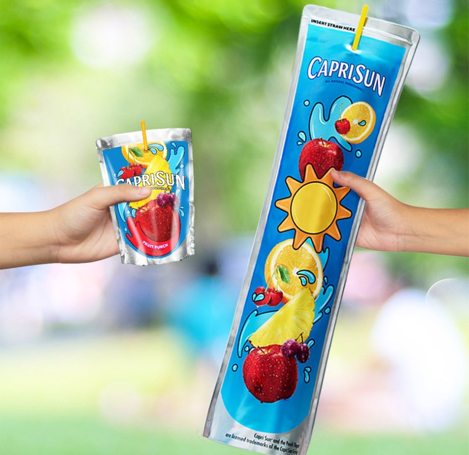 two hands holding capri sun juice pouches and one is extremely long