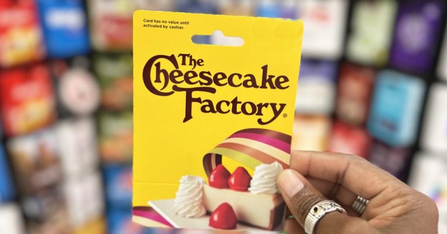 hand holding up a yellow Cheesecake Factory gift card