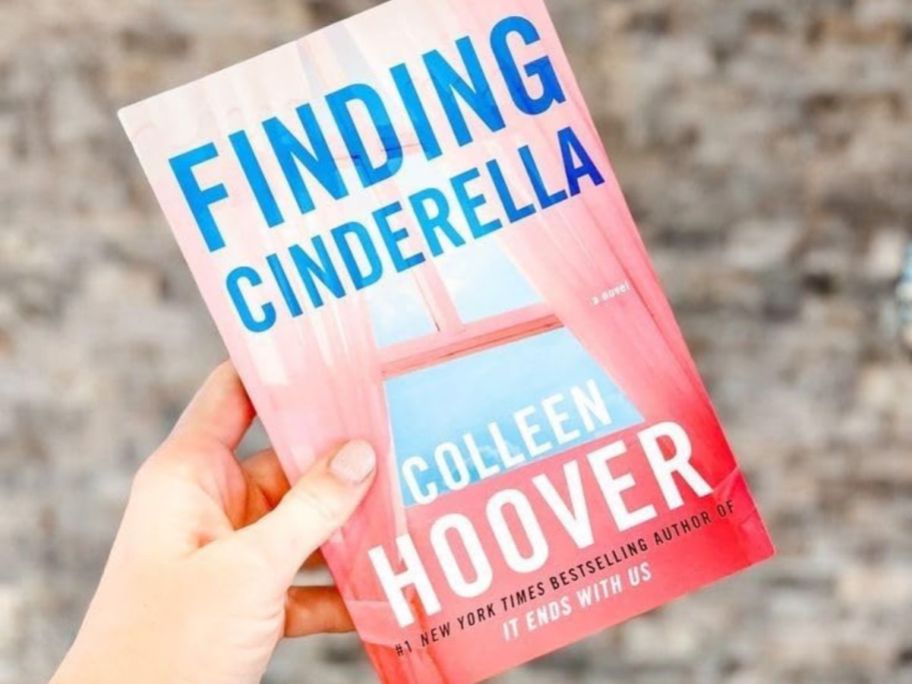 Hand holding Colleen Hoover Finding Cinderella Book