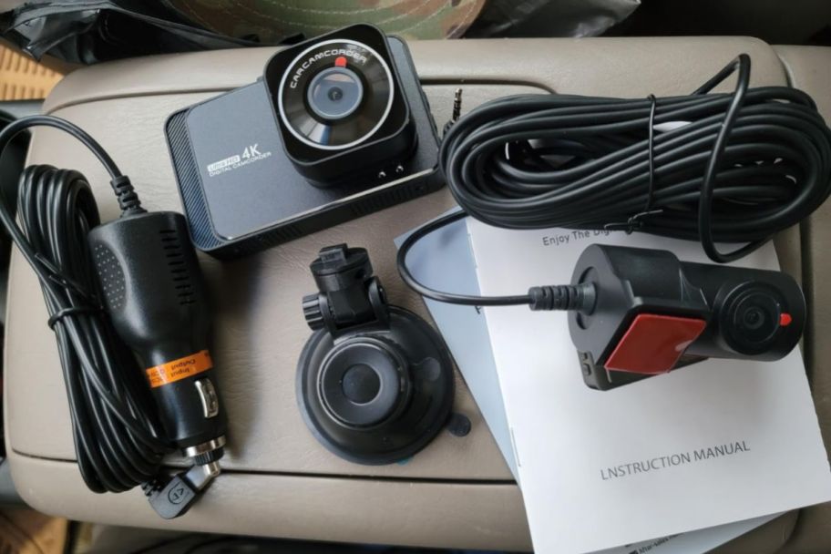 dashcam with all the items it comes with displayed inside of a car