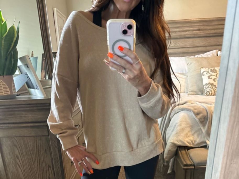 A woman wearing a tan sweatshirt