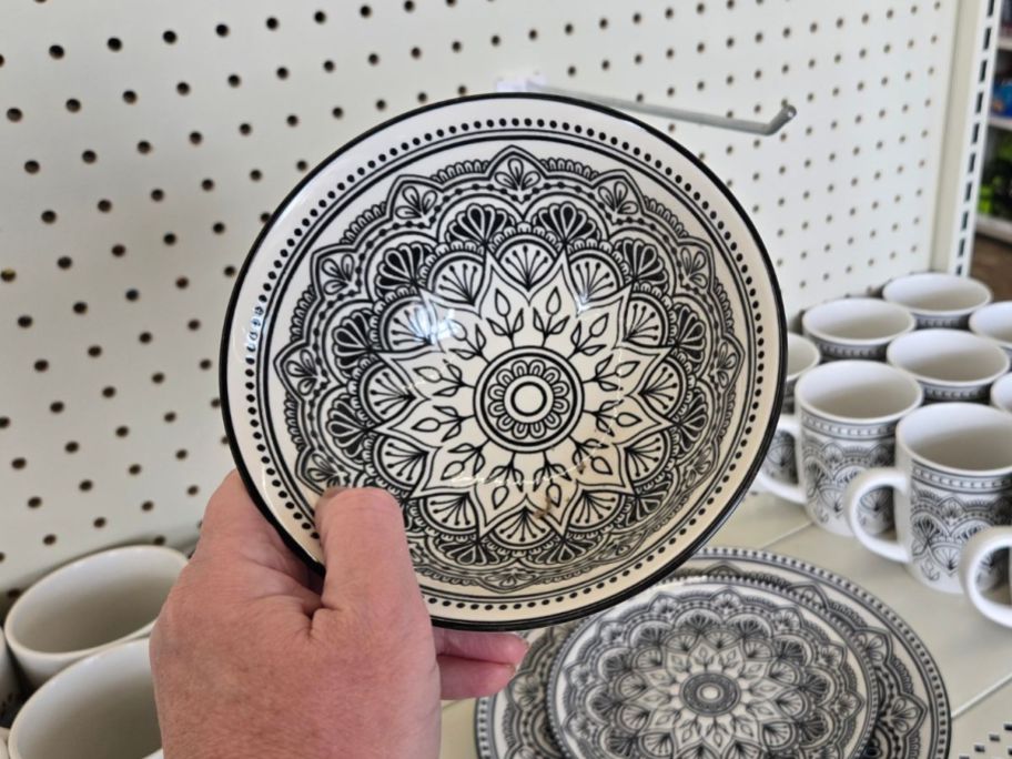 A person holding a black and white geometric patterned bowl
