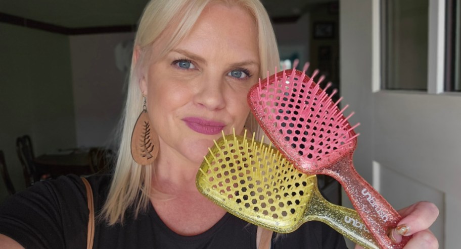 blonde woman holding up two unbrushes in pink and yellow