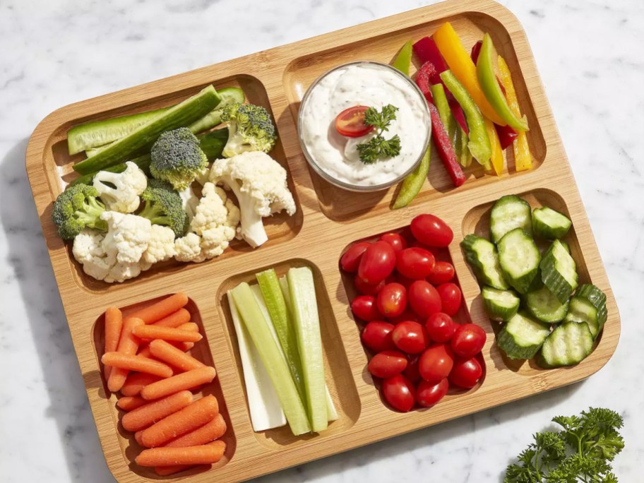 various vegetables in slots of charcuterie board