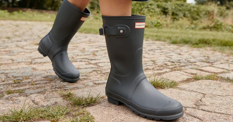 woman wearing black Hunter Rain Boots walking outside