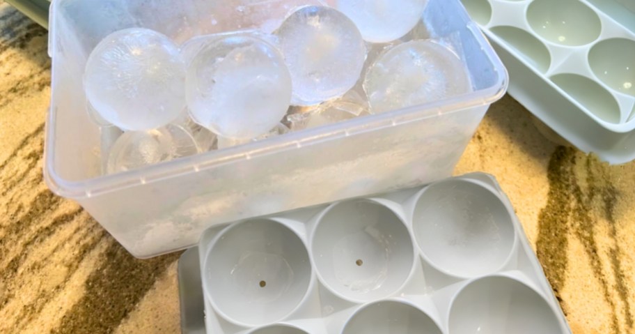 a bin with round ice cubes with round ice cube trays around it