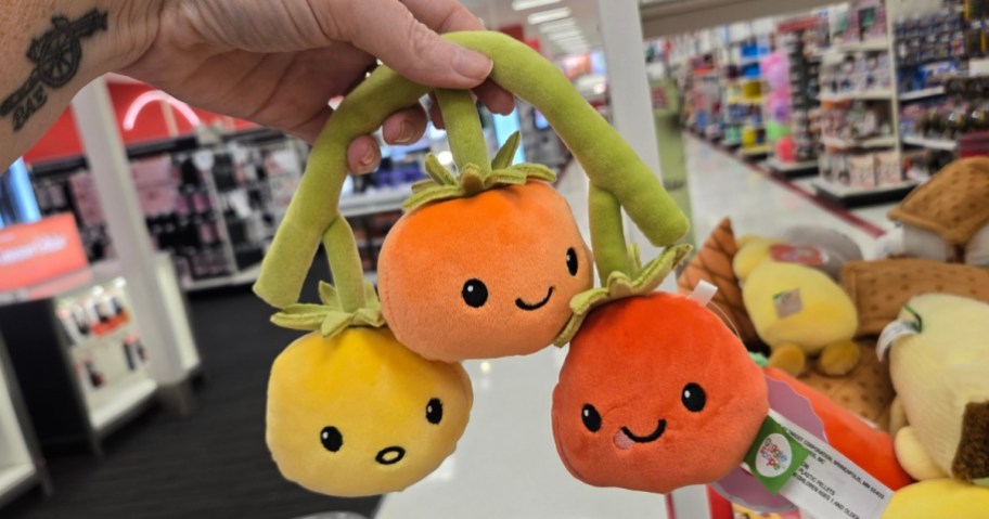 hand holding a plush tomato toy