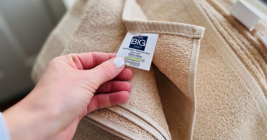 Hand showing the tag on The Big One Bath Towel from Kohl's