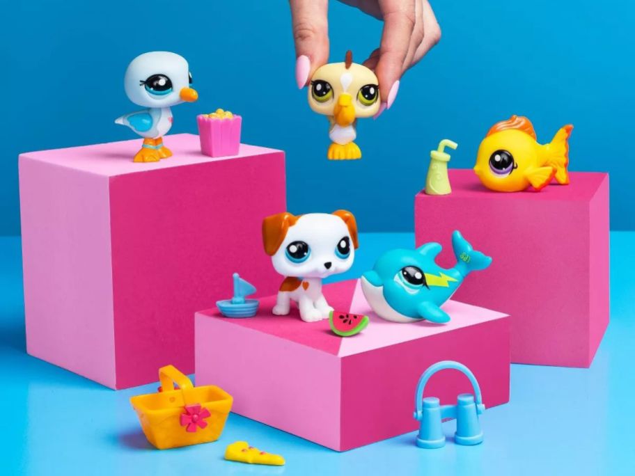 A person playing with small plastic animals 