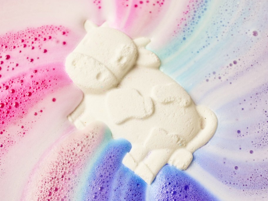 white cow bath bomb in colorful water