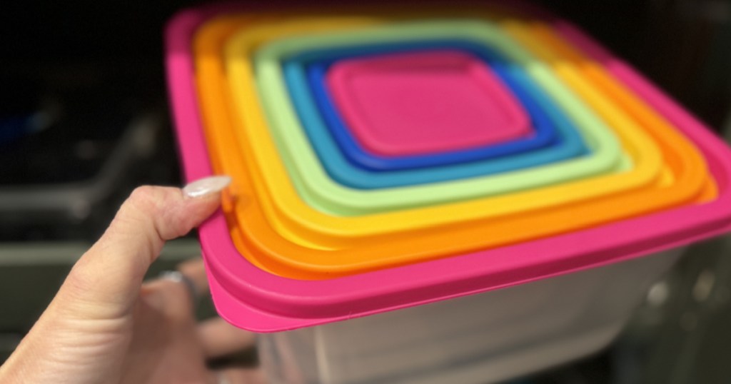 Women grabbing colorful, rainbow themed plastic container set from cabinet